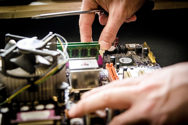 Primo piano di mani che installano un modulo RAM su una scheda madre