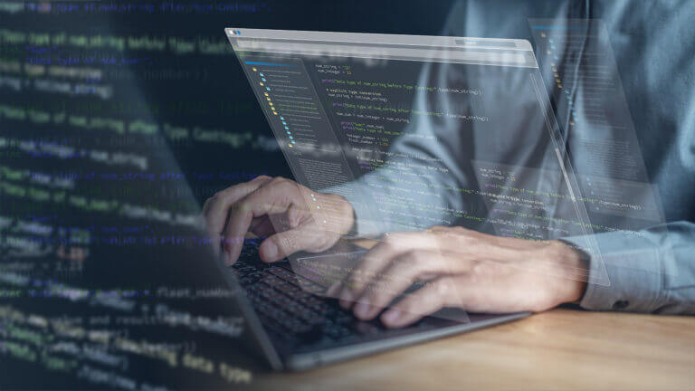 Sviluppo software: codice e lavoro su laptop con pannelli digitali
